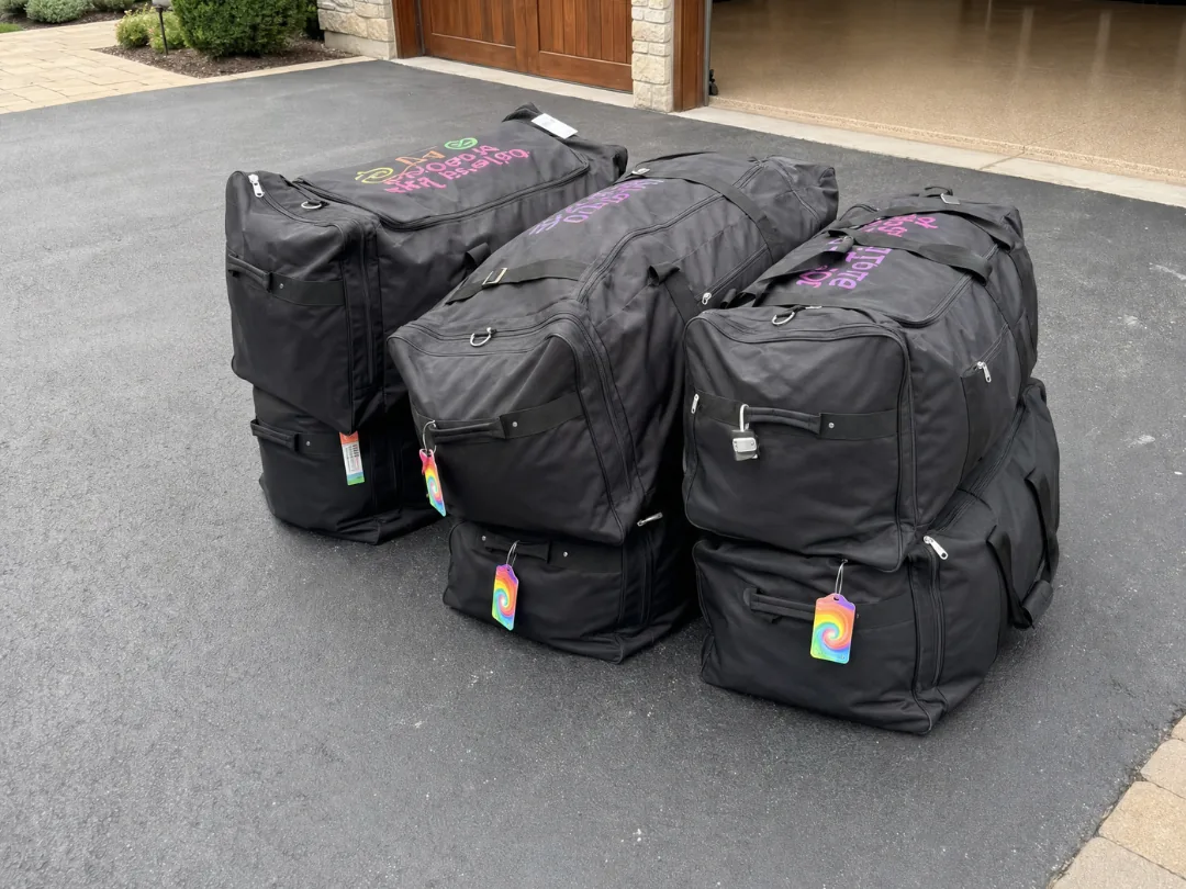 Tagged camp duffel bags stacked on the driveway, ready for pickup