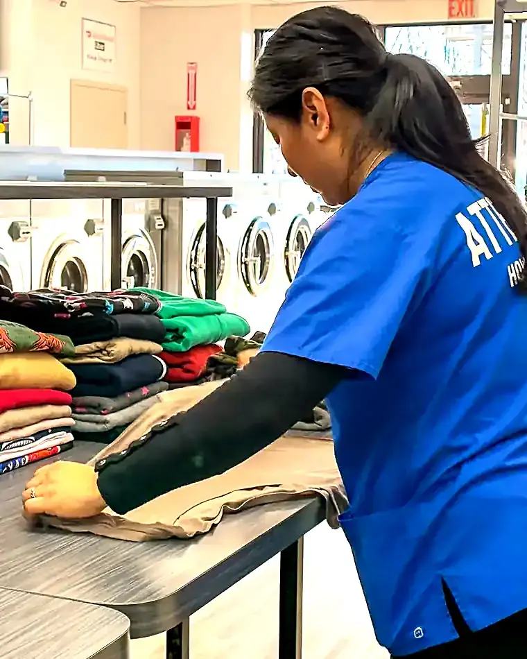 A Drop & Dash team member folding clean laundry at the Chicago facility