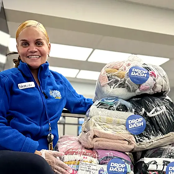 A smiling team member with packed orders